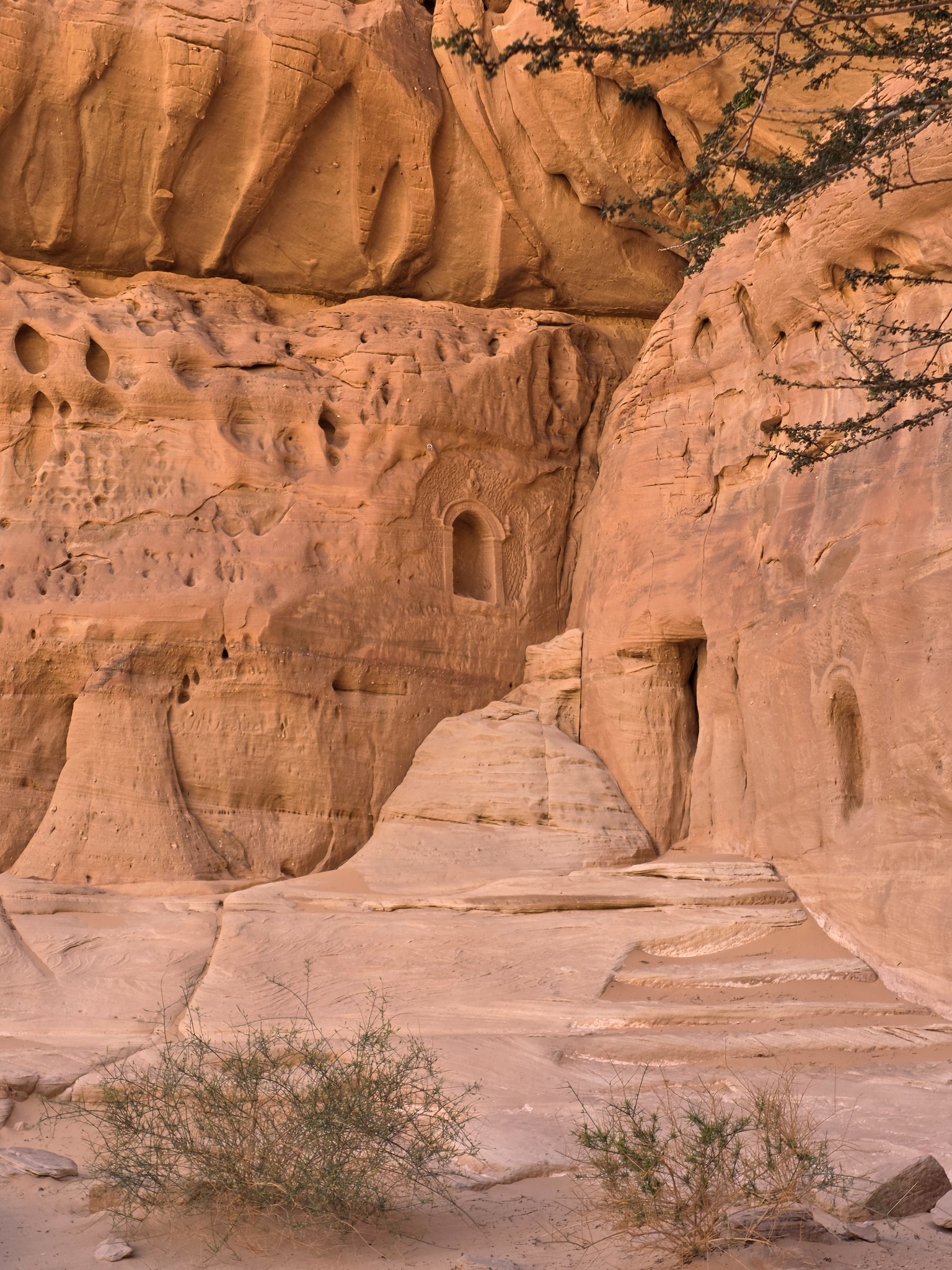 Una tumba de menor tamaño entre las paredes erosionadas de Hegra.