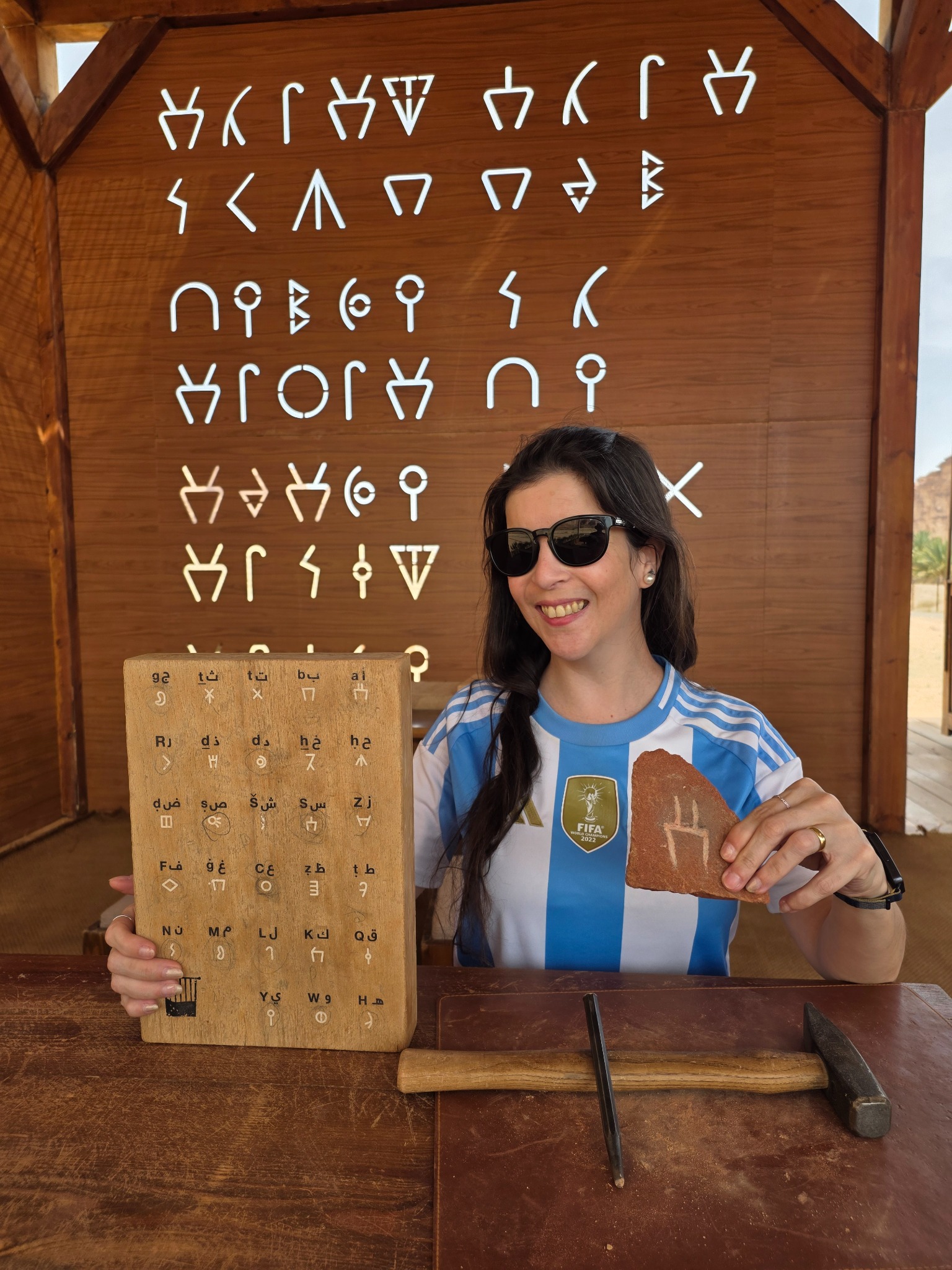 Aldana con la letra A que talló en piedra durante el taller de la excursión.