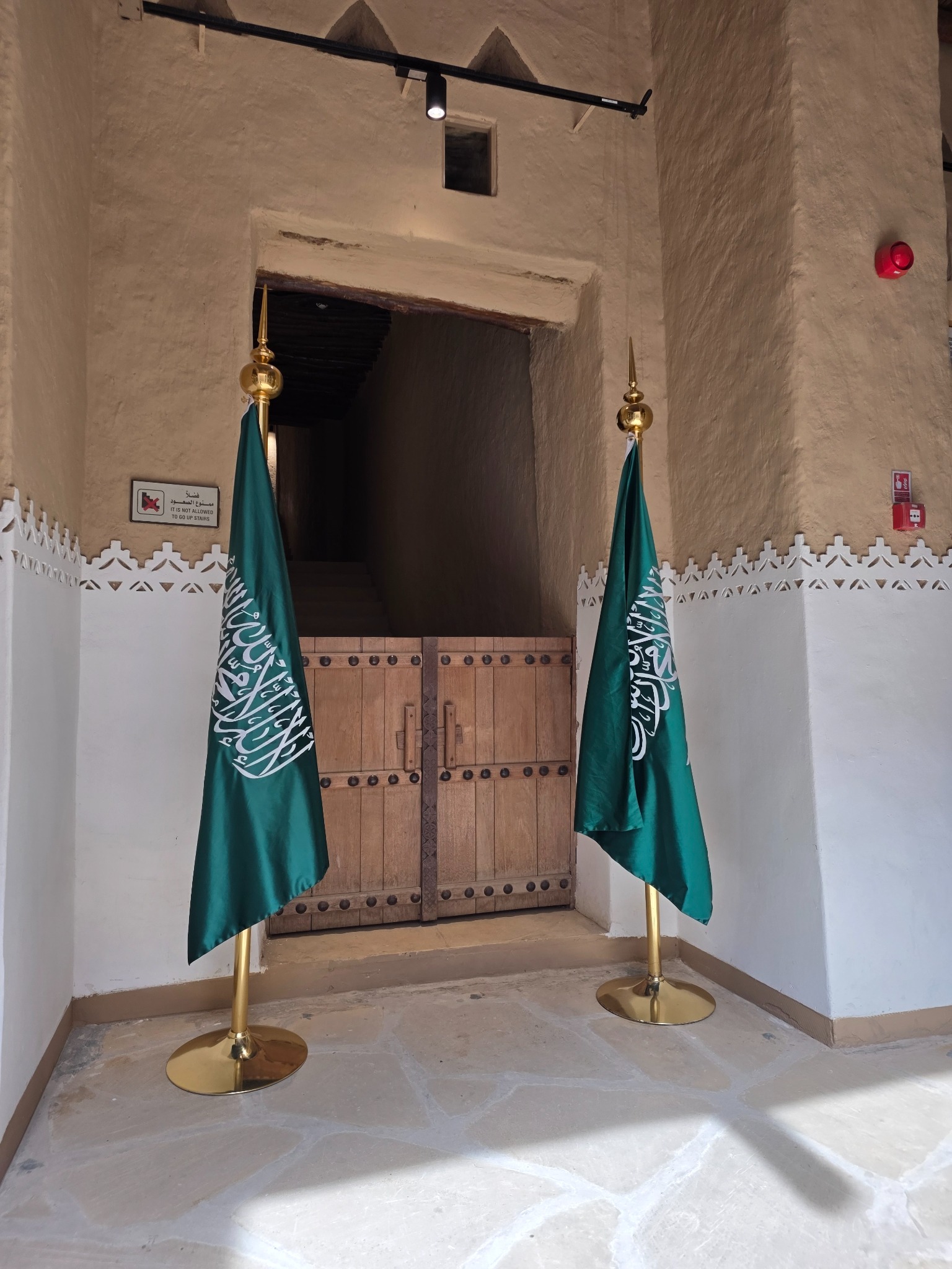 Una puerta del interior del fuerte, enmarcada por las banderas saudíes.