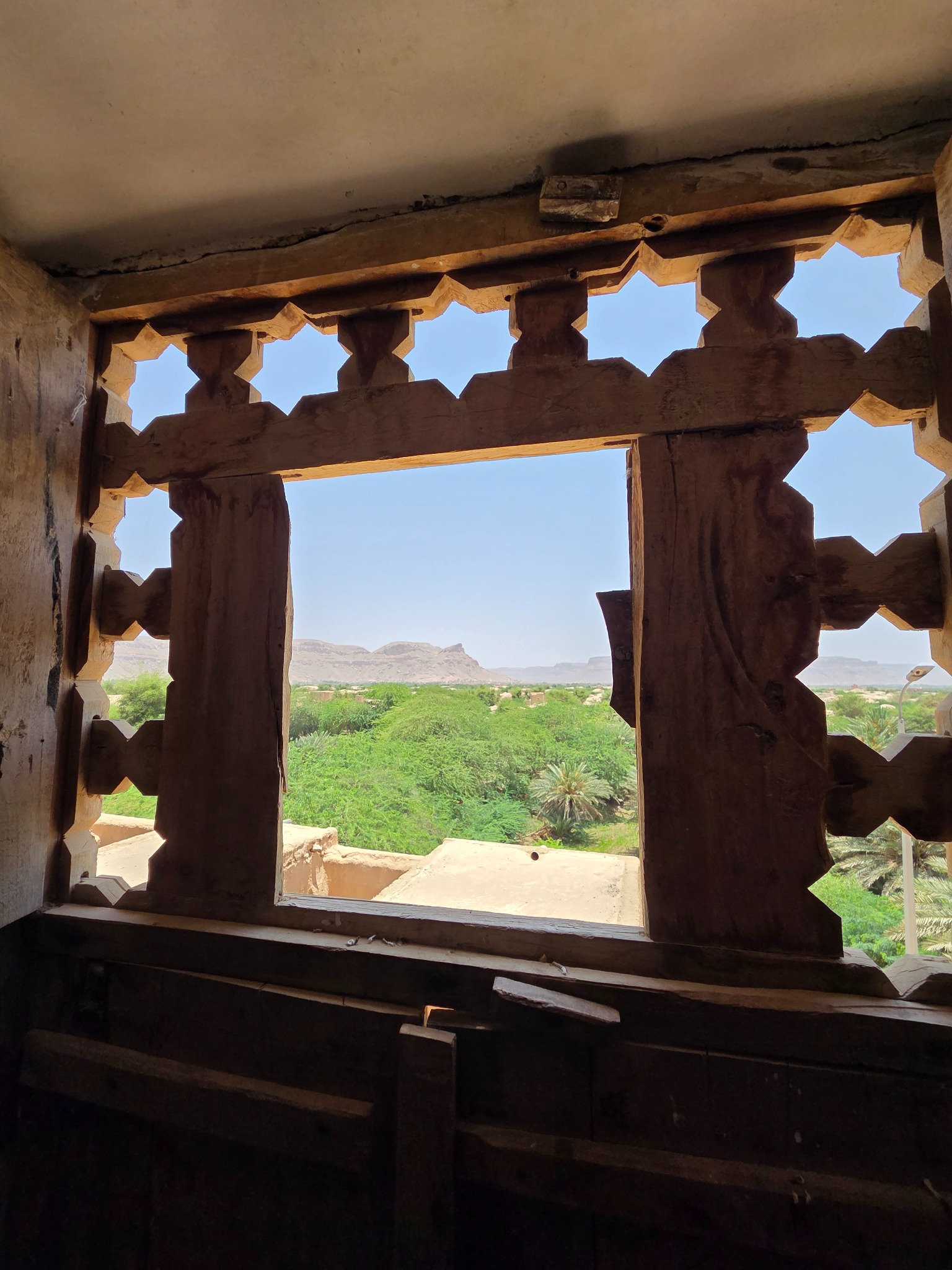 La vista desde una ventana de madera hacia el valle.